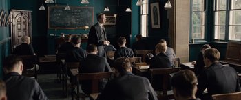Movie still from “The Imitation Game” (2014), directed by Morten Tyldum – A man standing in front of a group of students; Wide shot, Over the shoulder angle