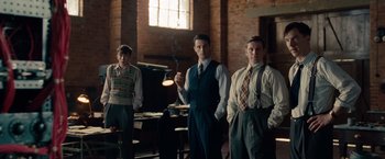 Movie still from “The Imitation Game” (2014), directed by Morten Tyldum – A group of men standing next to each other in a room; Medium shot, Low angle