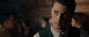 Movie still from “The Imitation Game” (2014), directed by Morten Tyldum – A person wearing a suit and tie; Close Up shot, Over the shoulder angle
