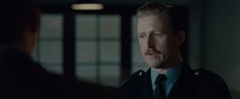 Movie still from “The Imitation Game” (2014), directed by Morten Tyldum – A person with a mustache wearing a uniform; Close Up shot, Over the shoulder angle