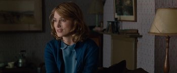 Movie still from “The Imitation Game” (2014), directed by Morten Tyldum – A woman sitting in front of a lamp in a living room; Close Up shot, Over the shoulder angle