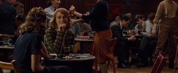 Movie still from “The Imitation Game” (2014), directed by Morten Tyldum – A woman sitting at a table in front of other people; Medium shot, Over the shoulder angle