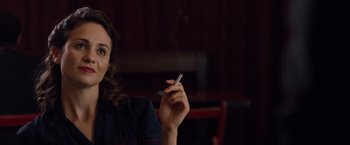 Movie still from “The Imitation Game” (2014), directed by Morten Tyldum – A woman is smoking a cigarette in a dark room; Close Up shot, Over the shoulder angle