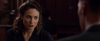 Movie still from “The Imitation Game” (2014), directed by Morten Tyldum – A beautiful woman with red lipstick sitting at a table; Close Up shot, Over the shoulder angle