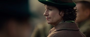 Movie still from “The Imitation Game” (2014), directed by Morten Tyldum – An older woman wearing a green hat looking to her left; Close Up shot, Over the shoulder angle