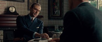 Movie still from “The Imitation Game” (2014), directed by Morten Tyldum – A man sitting at a table in a restaurant; Medium shot, Over the shoulder angle