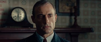 Movie still from “The Imitation Game” (2014), directed by Morten Tyldum – A person wearing a suit and tie; Close Up shot, Low angle