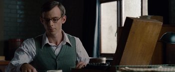 Movie still from “The Imitation Game” (2014), directed by Morten Tyldum – A man sitting at a table with a laptop; Medium shot, Low angle