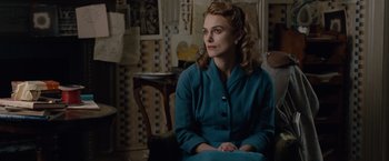 Movie still from “The Imitation Game” (2014), directed by Morten Tyldum – A woman sitting in a chair in a room; Medium shot, Over the shoulder angle