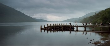 Movie still from “The Last King of Scotland” (2006), directed by Kevin Macdonald – Two people are walking on a pier in the water; Extreme Wide shot, Low angle