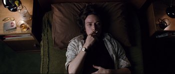 Movie still from “The Last King of Scotland” (2006), directed by Kevin Macdonald – A man laying in bed with his hand under his chin; Medium shot, Overhead angle