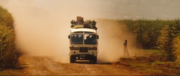 Movie still from “The Last King of Scotland” (2006), directed by Kevin Macdonald – A bus driving down a dirt road near a forest; Extreme Wide shot, Low angle