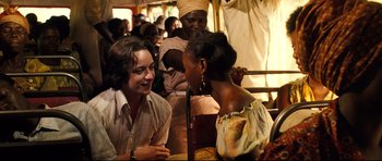 Movie still from “The Last King of Scotland” (2006), directed by Kevin Macdonald – Two people talking to each other while others watch; Medium shot, Over the shoulder angle