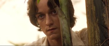 Movie still from “The Last King of Scotland” (2006), directed by Kevin Macdonald – A person holding a plant; Close Up shot, Low angle