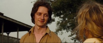 Movie still from “The Last King of Scotland” (2006), directed by Kevin Macdonald – A man with long brown hair wearing a brown shirt; Close Up shot, Over the shoulder angle