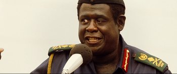 Movie still from “The Last King of Scotland” (2006), directed by Kevin Macdonald – A person holding a microphone on a microphone stand; Close Up shot, Low angle