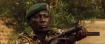 Movie still from “The Last King of Scotland” (2006), directed by Kevin Macdonald – A man in a military uniform holding a rifle; Close Up shot, Low angle