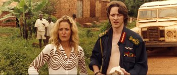 Movie still from “The Last King of Scotland” (2006), directed by Kevin Macdonald – A man and a woman standing next to each other; Medium shot, Over the shoulder angle