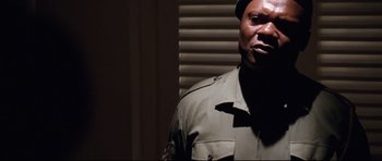 Movie still from “The Last King of Scotland” (2006), directed by Kevin Macdonald – A man in a uniform is standing in front of a window; Close Up shot, Low angle