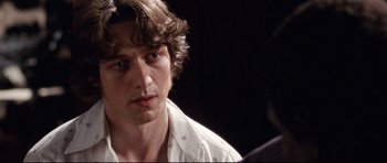 Movie still from “The Last King of Scotland” (2006), directed by Kevin Macdonald – A person wearing a white shirt; Close Up shot, Over the shoulder angle