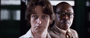 Movie still from “The Last King of Scotland” (2006), directed by Kevin Macdonald – A man in a white shirt and a man in a brown shirt; Close Up shot, Low angle