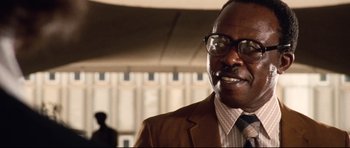 Movie still from “The Last King of Scotland” (2006), directed by Kevin Macdonald – A person wearing a suit and tie; Close Up shot, Low angle