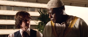 Movie still from “The Last King of Scotland” (2006), directed by Kevin Macdonald – A man and a woman standing next to each other; Close Up shot, Over the shoulder angle