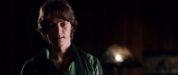 Movie still from “The Last King of Scotland” (2006), directed by Kevin Macdonald – A young man in a green shirt is looking at the camera; Close Up shot, Over the shoulder angle
