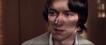 Movie still from “The Last King of Scotland” (2006), directed by Kevin Macdonald – A person wearing a suit and tie; Close Up shot, Overhead angle