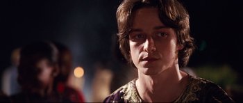 Movie still from “The Last King of Scotland” (2006), directed by Kevin Macdonald – A person with long brown hair; Close Up shot, Over the shoulder angle