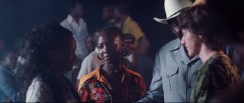 Movie still from “The Last King of Scotland” (2006), directed by Kevin Macdonald – A group of people standing in a room; Medium shot, Over the shoulder angle