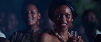 Movie still from “The Last King of Scotland” (2006), directed by Kevin Macdonald – Two women are posing for a picture in the dark; Close Up shot, Low angle