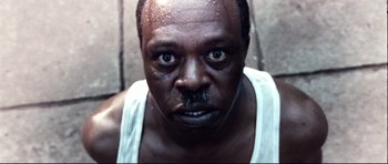 Movie still from “The Last King of Scotland” (2006), directed by Kevin Macdonald – A person wearing a tank top; Extreme Close Up shot, Low angle