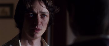 Movie still from “The Last King of Scotland” (2006), directed by Kevin Macdonald – A person's face in a dark room; Close Up shot, Over the shoulder angle