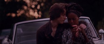 Movie still from “The Last King of Scotland” (2006), directed by Kevin Macdonald – A man and a woman sitting next to each other; Medium shot, Over the shoulder angle