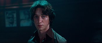 Movie still from “The Last King of Scotland” (2006), directed by Kevin Macdonald – A young man in a green shirt is looking at the camera; Close Up shot, Low angle