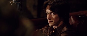 Movie still from “The Last King of Scotland” (2006), directed by Kevin Macdonald – A person wearing a brown shirt; Close Up shot, Over the shoulder angle