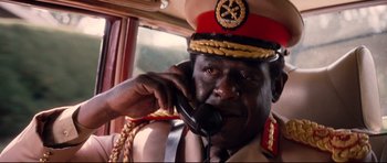Movie still from “The Last King of Scotland” (2006), directed by Kevin Macdonald – A man in a military uniform talking on a phone; Close Up shot, High angle
