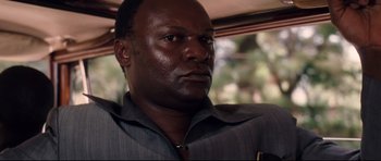 Movie still from “The Last King of Scotland” (2006), directed by Kevin Macdonald – A person wearing a suit; Close Up shot, Low angle