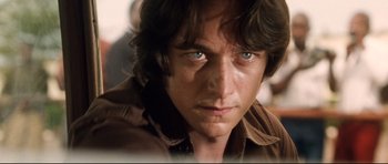 Movie still from “The Last King of Scotland” (2006), directed by Kevin Macdonald – A man with blue eyes looking at the camera; Close Up shot, Low angle