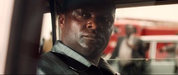 Movie still from “The Last King of Scotland” (2006), directed by Kevin Macdonald – A person wearing a shirt and tie; Close Up shot, Over the shoulder angle