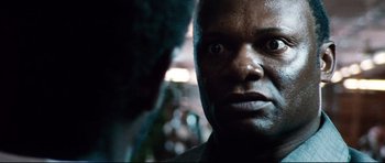 Movie still from “The Last King of Scotland” (2006), directed by Kevin Macdonald – A man's face in the dark; Close Up shot, Over the shoulder angle