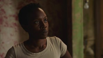 Movie still from “The Last of Us” (2023), created by Neil Druckmann – A person wearing a white t - shirt; Close Up shot, Over the shoulder angle