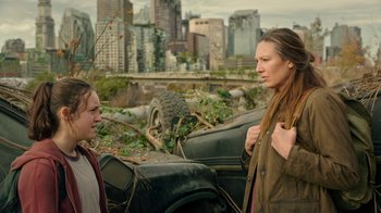 Movie still from “The Last of Us” (2023), created by Neil Druckmann – Two people standing next to a car in the middle of a city; Medium shot, Over the shoulder angle