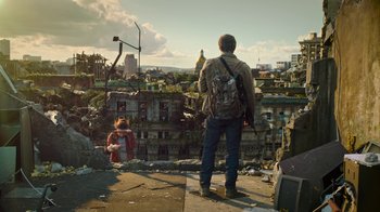 Movie still from “The Last of Us” (2023), created by Neil Druckmann – A man standing on the side of a building looking at a girl; Wide shot, Low angle
