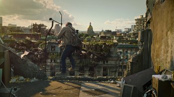 Movie still from “The Last of Us” (2023), created by Neil Druckmann – A man standing on top of a building near a bunch of buildings; Wide shot, Low angle