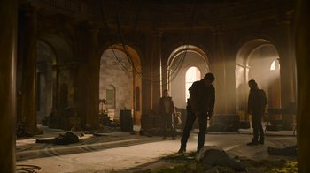 Movie still from “The Last of Us” (2023), created by Neil Druckmann – A man standing in the middle of an empty room; Wide shot, Low angle