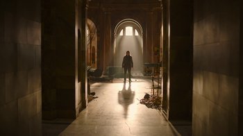 Movie still from “The Last of Us” (2023), created by Neil Druckmann – A man standing in the middle of an empty room; Extreme Wide shot, Low angle