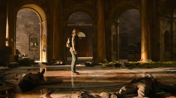 Movie still from “The Last of Us” (2023), created by Neil Druckmann – A person with a backpack standing in a room; Wide shot, High angle