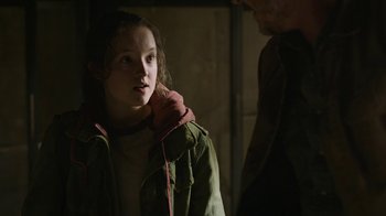 Movie still from “The Last of Us” (2023), created by Neil Druckmann – A young girl in a green jacket is looking at a man; Close Up shot, Over the shoulder angle